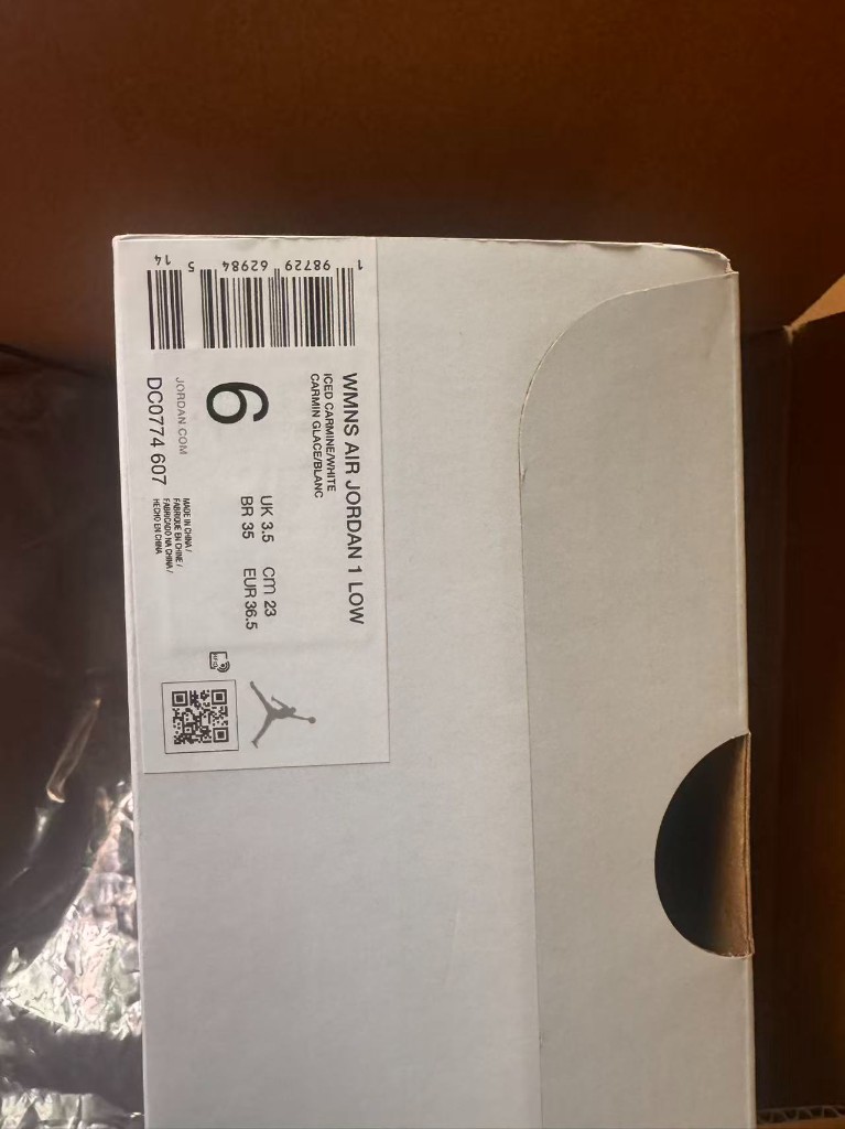 鞋盒侧面标签,印有 WMNS AIR JORDAN 1 LOW、货号 DC0774 607 和各体系尺码